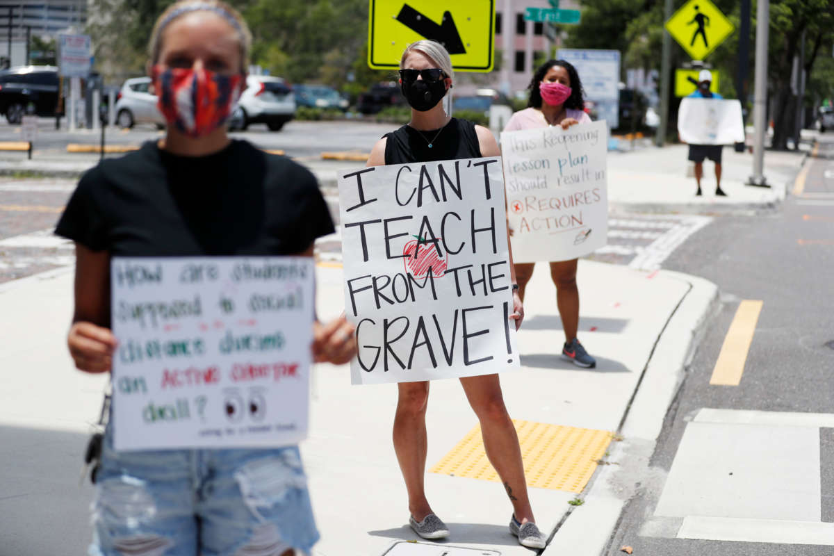 Middle school teacher Brittany Myers, center, stands in protest in front of the Hillsborough County Schools District Office on July 16, 2020 in Tampa, Florida.
