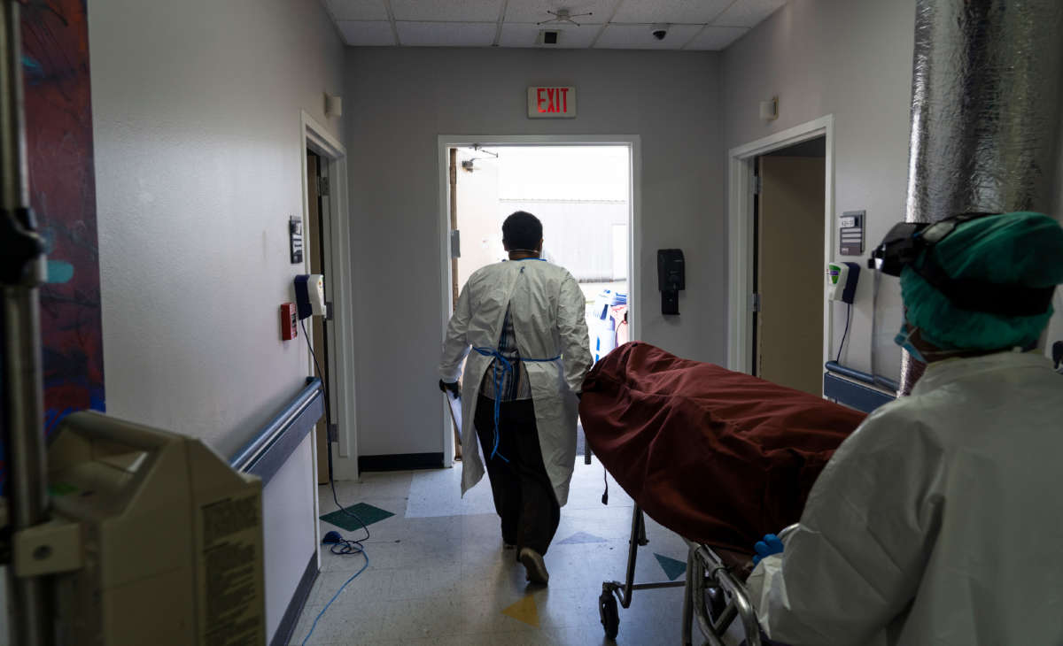 Medical staff push a stretcher with a deceased patient out of the COVID-19 intensive care unit at the United Memorial Medical Center on June 30, 2020, in Houston, Texas.