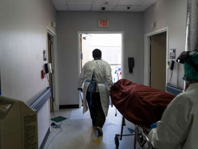 Medical staff push a stretcher with a deceased patient out of the COVID-19 intensive care unit at the United Memorial Medical Center on June 30, 2020, in Houston, Texas.