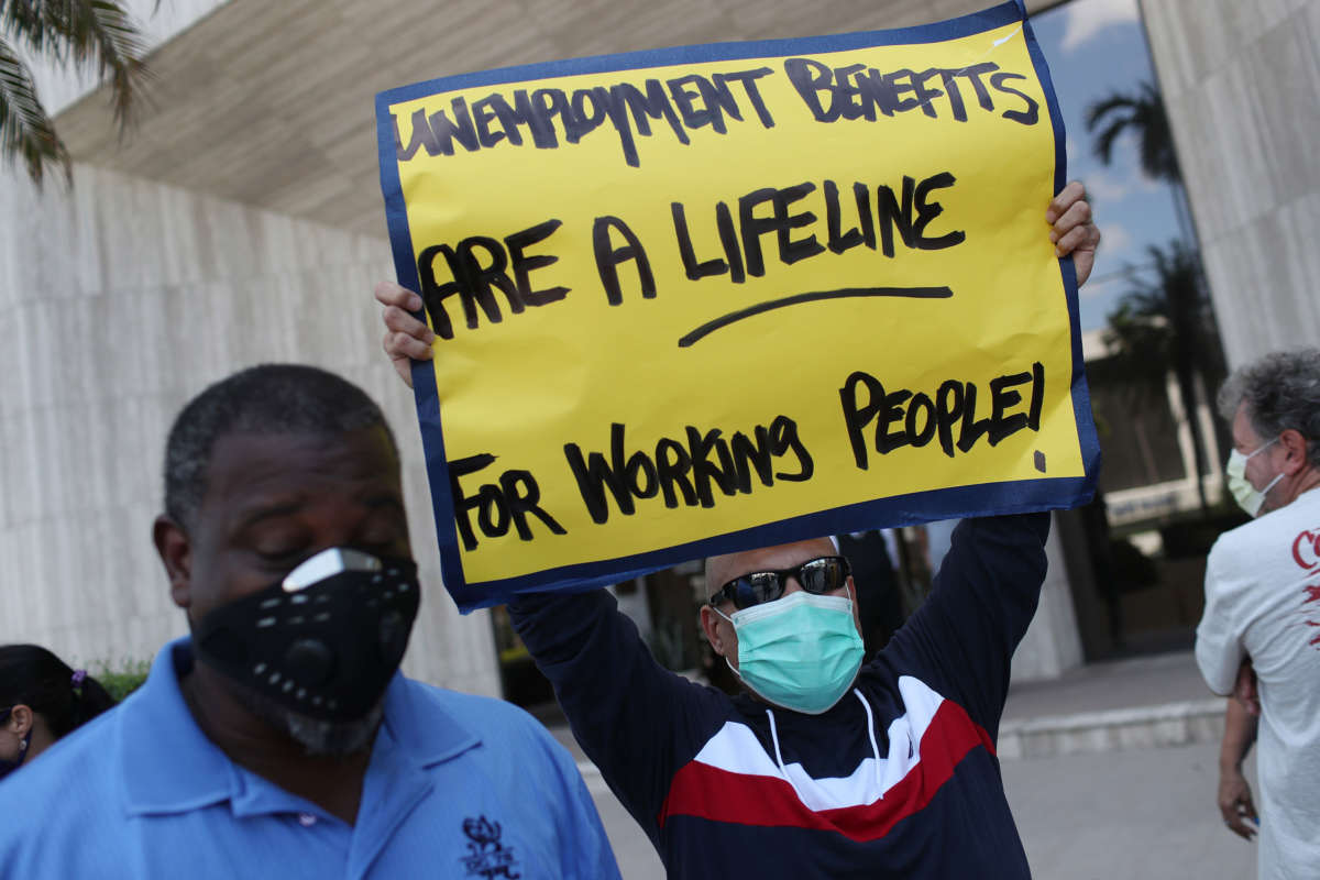 Carlos Ponce joins other demonstrators participating in a protest asking Senators to support the continuation of unemployment benefits, on July 16, 2020, in Miami Springs, Florida.