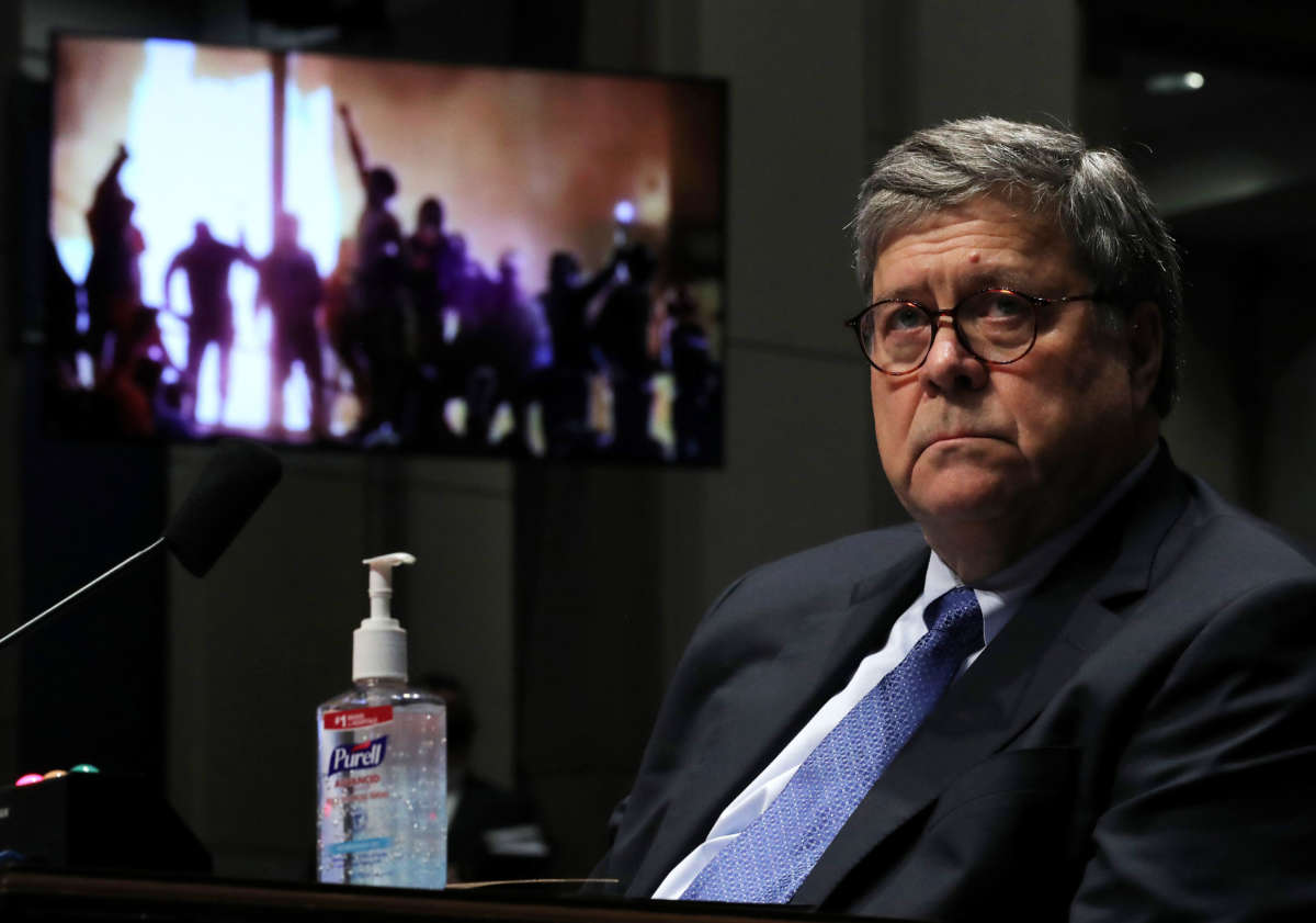 Attorney General William Barr watches a Republican Exhibit video during a House Judiciary Committee hearing, July 28, 2020, in Washington, D.C.