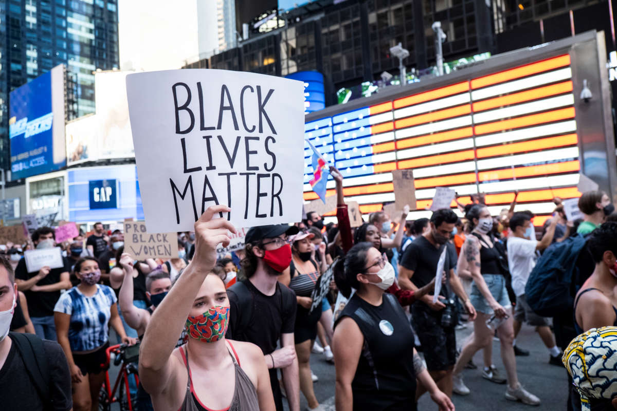 A protester holds a sign reading "BLACK LIVES MATTER" during a march