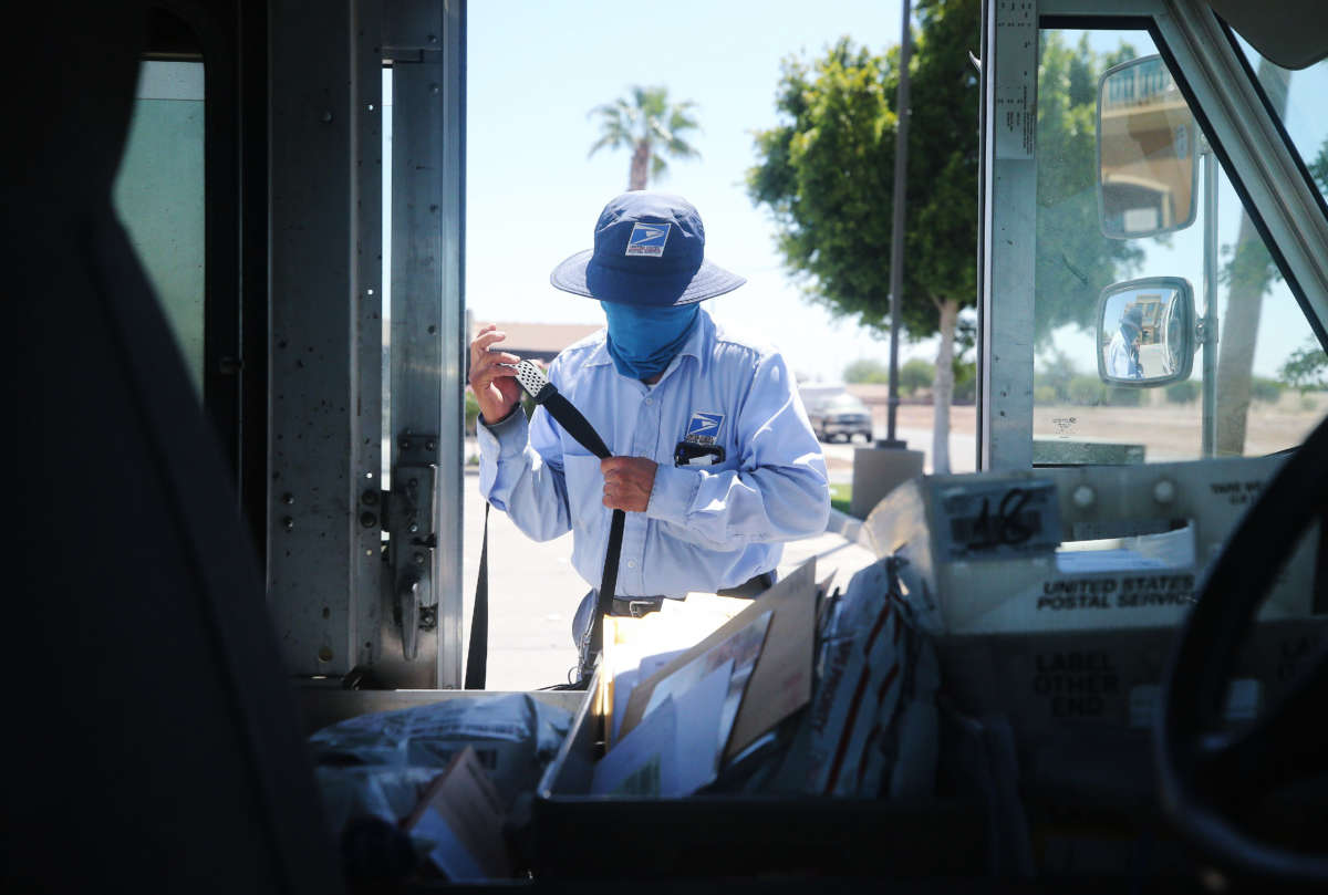 A USPS postal worker wears a face mask amid the COVID-19 pandemic in hard-hit Imperial County on July 21, 2020, in El Centro, California.