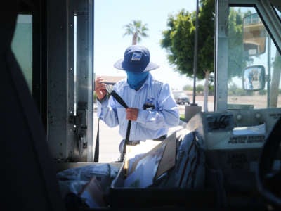A USPS postal worker wears a face mask amid the COVID-19 pandemic in hard-hit Imperial County on July 21, 2020, in El Centro, California.