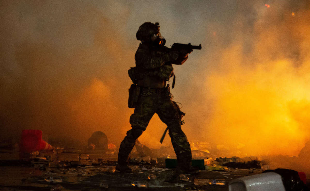 A federal officer points a less-lethal weapon toward a crowd of a few hundred protesters in front of the Mark O. Hatfield U.S. Courthouse on July 23, 2020, in Portland, Oregon.