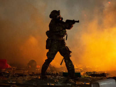 A federal officer points a less-lethal weapon toward a crowd of a few hundred protesters in front of the Mark O. Hatfield U.S. Courthouse on July 23, 2020, in Portland, Oregon.