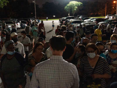 People crowd around an OESC employee to get a number at an unemployment event in Tulsa, Oklahoma, on July 15, 2020.