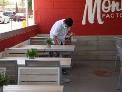 A worker cleans patio tables at the Armenian cuisine restaurant Monta Factory on July 2, 2020, in Glendale, California, after Los Angeles County restaurants were force by state order to shut their doors again to dine-in eating due to a spike in COVID-19 cases.