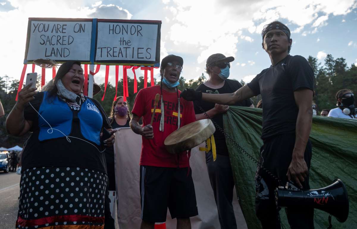 Activists and members of different tribes from the region block the road to Mount Rushmore National Monument as they protest in Keystone, South Dakota, on July 3, 2020, during a demonstration around the Mount Rushmore National Monument and the visit of Donald Trump.