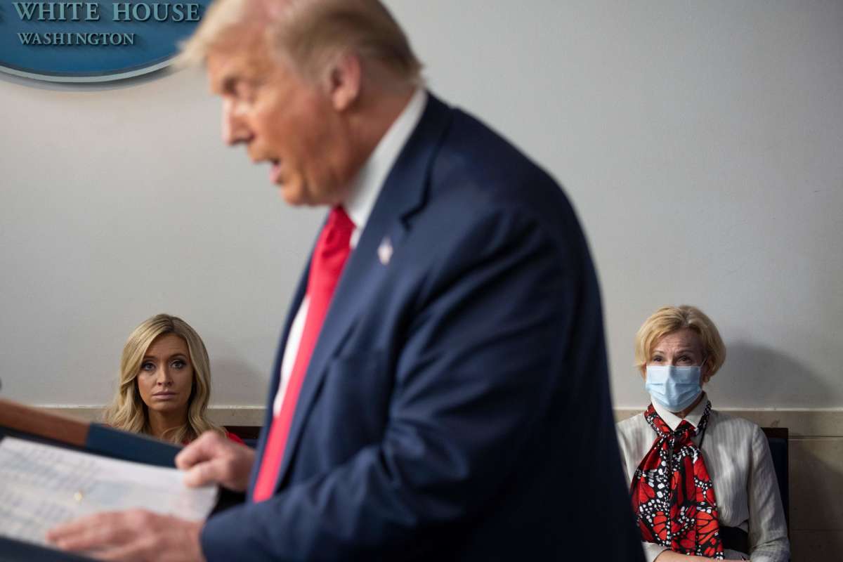 White House Press Secretary Kayleigh McEnany (left), not wearing a facemask, sits next to Response coordinator for White House Coronavirus Task Force Deborah Birx, wearing a facemask, as they listen to Donald Trump deliver a news conference in the Brady Briefing Room of the White House in Washington, D.C., on July 23, 2020.