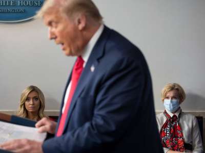 White House Press Secretary Kayleigh McEnany (left), not wearing a facemask, sits next to Response coordinator for White House Coronavirus Task Force Deborah Birx, wearing a facemask, as they listen to Donald Trump deliver a news conference in the Brady Briefing Room of the White House in Washington, D.C., on July 23, 2020.