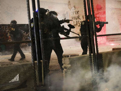 Police guard the Mark O. Hatfield federal courthouse in downtown Portland as the city experiences another night of unrest on July 24, 2020, in Portland, Oregon.