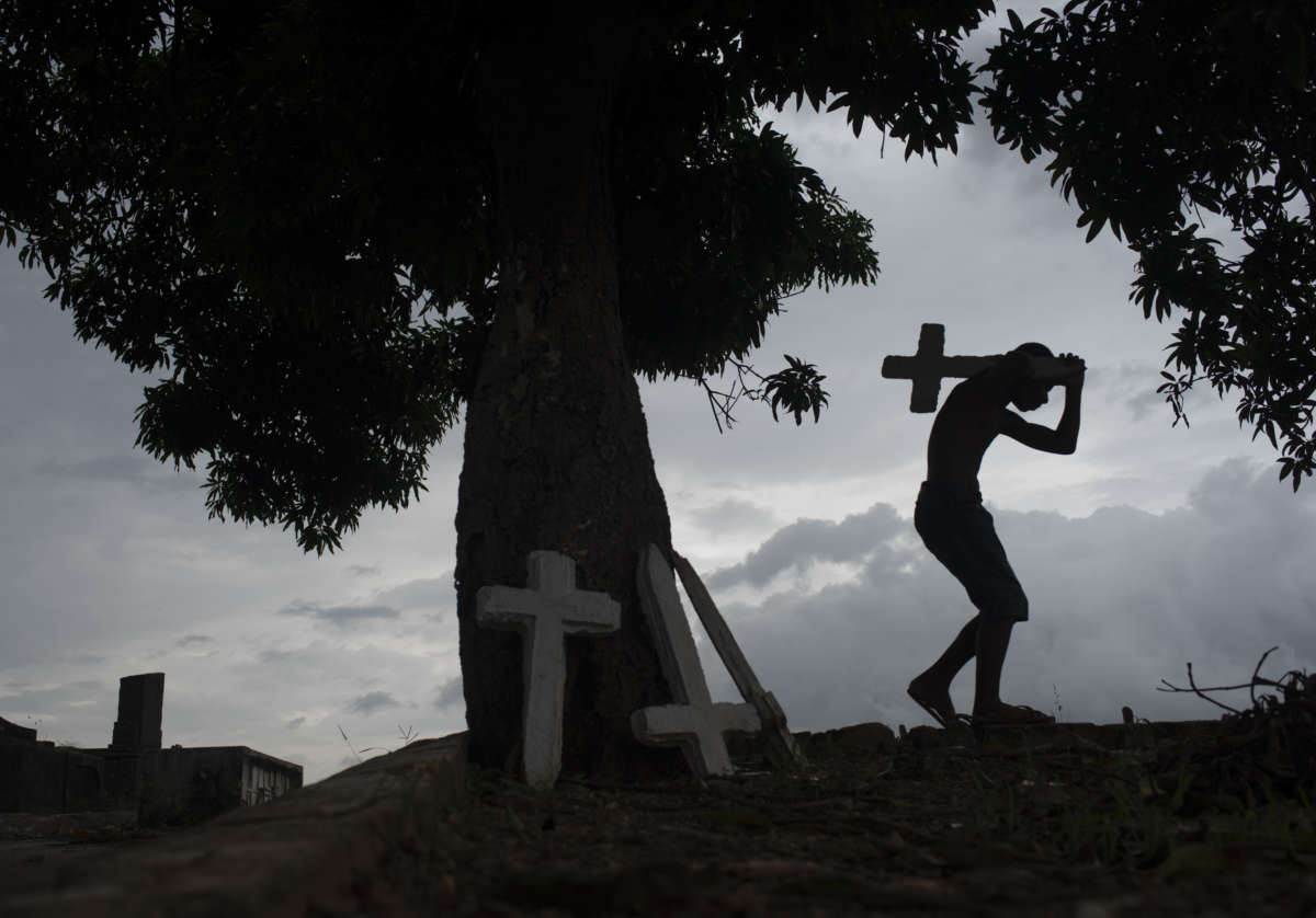 Josué Vicente Pereira carries the finished crosses to the graves.
