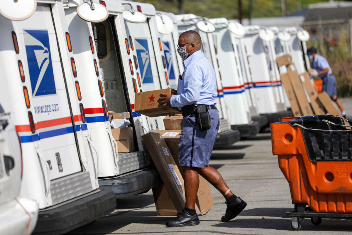 A postal carrier loads mail in his truck for delivery at San Clemente Post Office on May 15, 2020, in San Clemente, California.