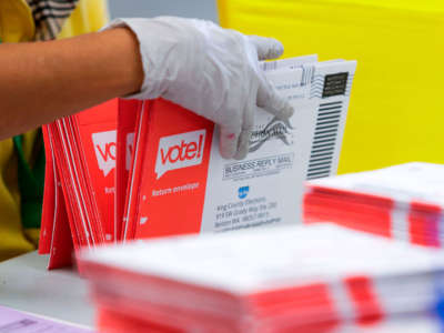 An election worker opens envelopes containing vote-by-mail ballots for the Washington state primary at King County Elections in Renton, Washington, on August 3, 2020.