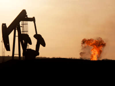 تشتعل مضخة جاك بئر النفط والغاز الطبيعي عند غروب الشمس في حقل نفط باكن شمال ويليستون، داكوتا الشمالية.