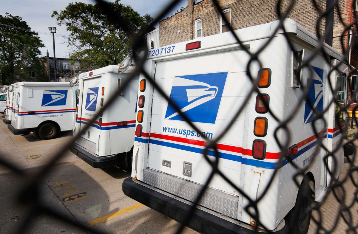 usps trucks sit unused in a chained up parking lot