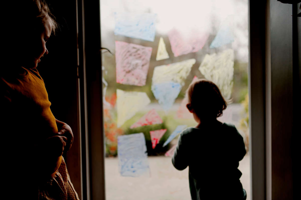 Family, children painting on glass door