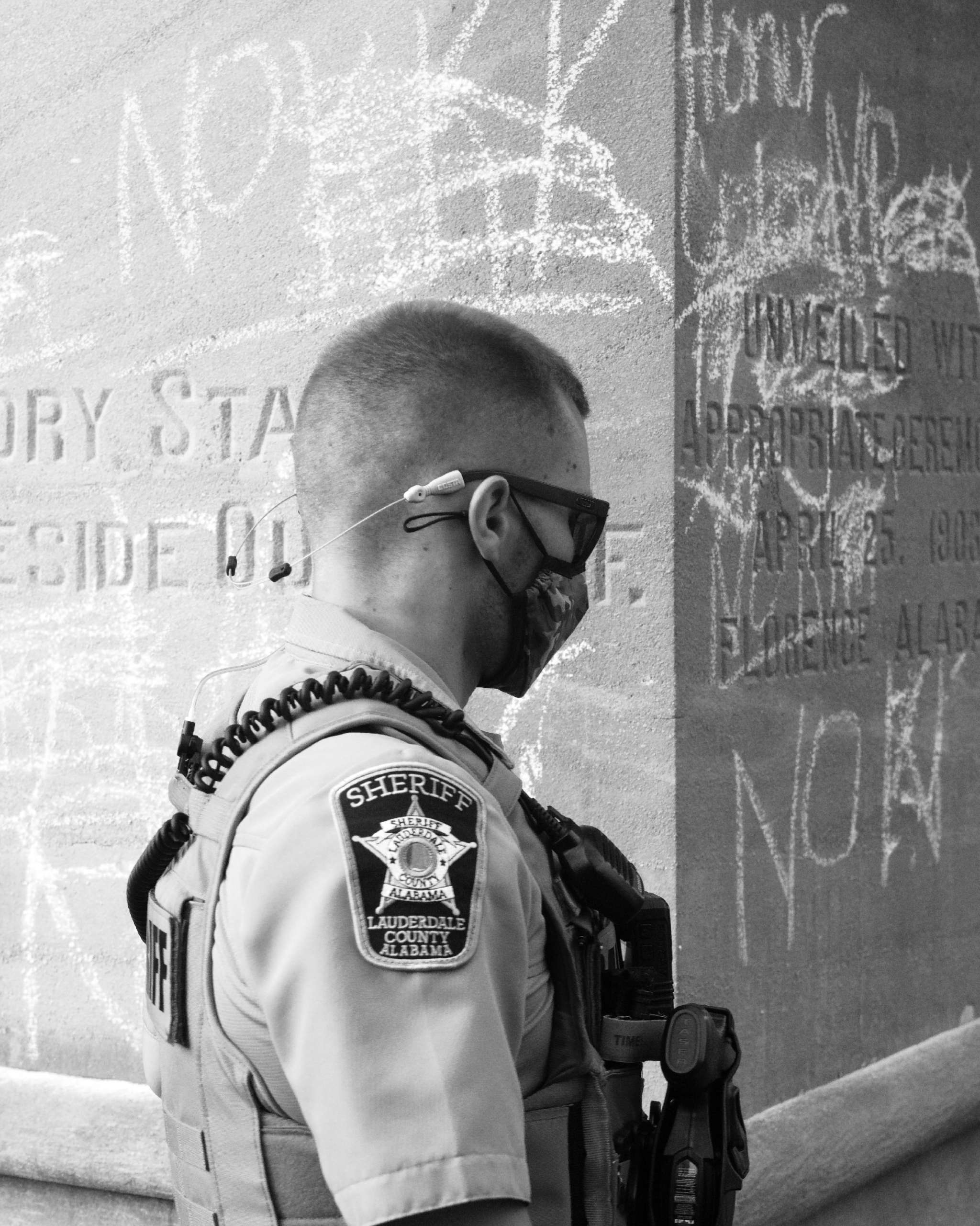An officer walks past the chalked-up monument on July 27, 2020. No permanent damage was done and chalk was removed.