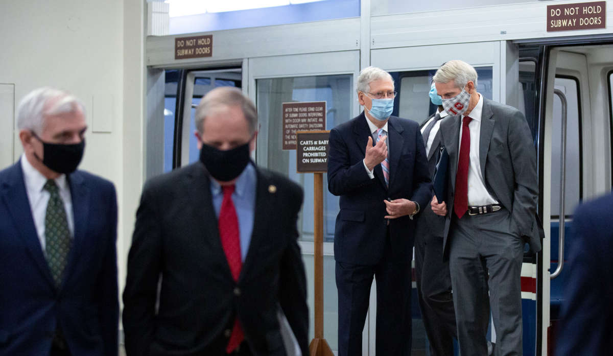 Senate Majority Leader Mitch McConnell, third from left, speaks to U.S. Sen. Rob Portman, second right, in the Senate Subway under the U.S. Capitol on August 6, 2020, in Washington, D.C.