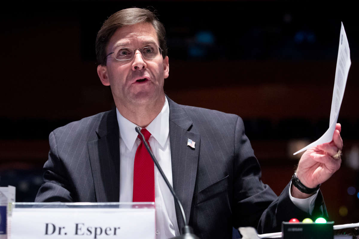 Mark Esper holds a piece of paper during a hearing