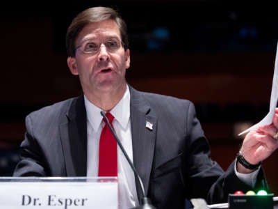 Mark Esper holds a piece of paper during a hearing