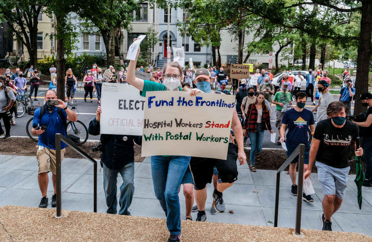 Demonstrators gather outside of the condo of President Trump donor and current U.S. Postmaster General Louis Dejoy on August 15, 2020, in Washington, D.C.