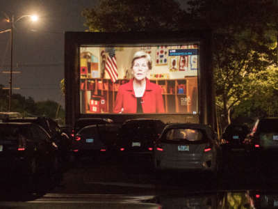 A screen projects Sen. Elizabeth Warren during a drive-in watch party for the virtual Democratic National Convention hosted by the Massachusetts Democrats at Suffolk Downs on August 19, 2020, in Boston, Massachusetts.