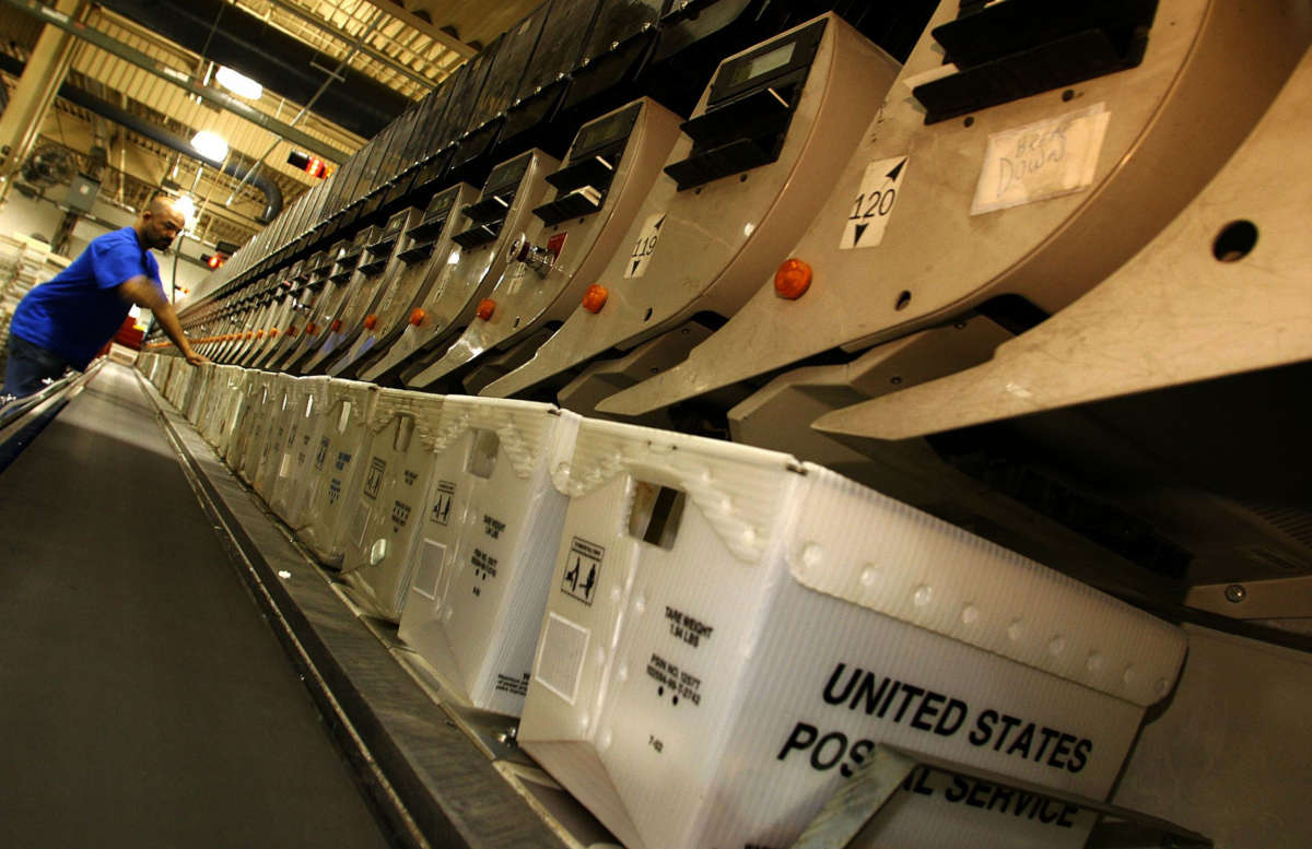 A postal employee attends to an automated sorting machine at the United States Postal Service's processing and distribution center in Capitol Heights, Maryland, December 19, 2002.