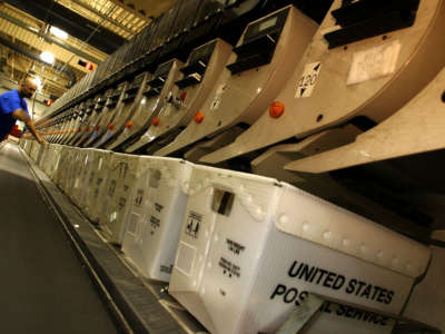 A postal employee attends to an automated sorting machine at the United States Postal Service's processing and distribution center in Capitol Heights, Maryland, December 19, 2002.