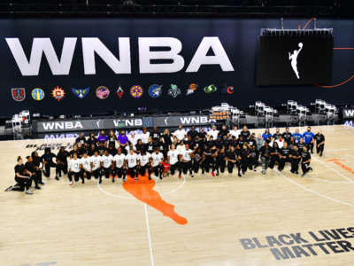 The Atlanta Dream, Washington Mystics, Minnesota Lynx, and the Los Angeles Sparks kneel on the court after the teams collectively decided to postpone games at Feld Entertainment Center on August 26, 2020, in Palmetto, Florida.