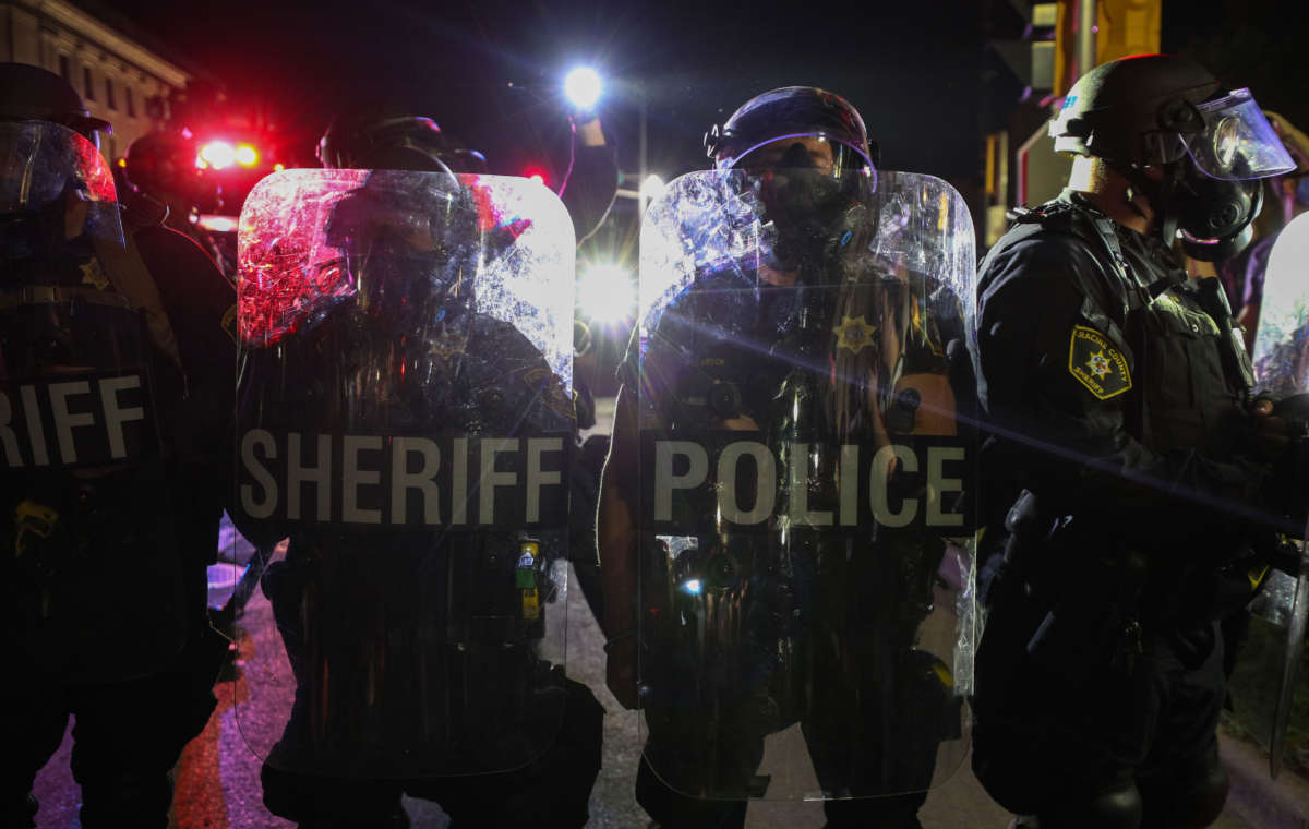 Police stand with shields during a third night of unrest on August 25, 2020, in Kenosha, Wisconsin.