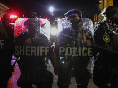 Police stand with shields during a third night of unrest on August 25, 2020, in Kenosha, Wisconsin.