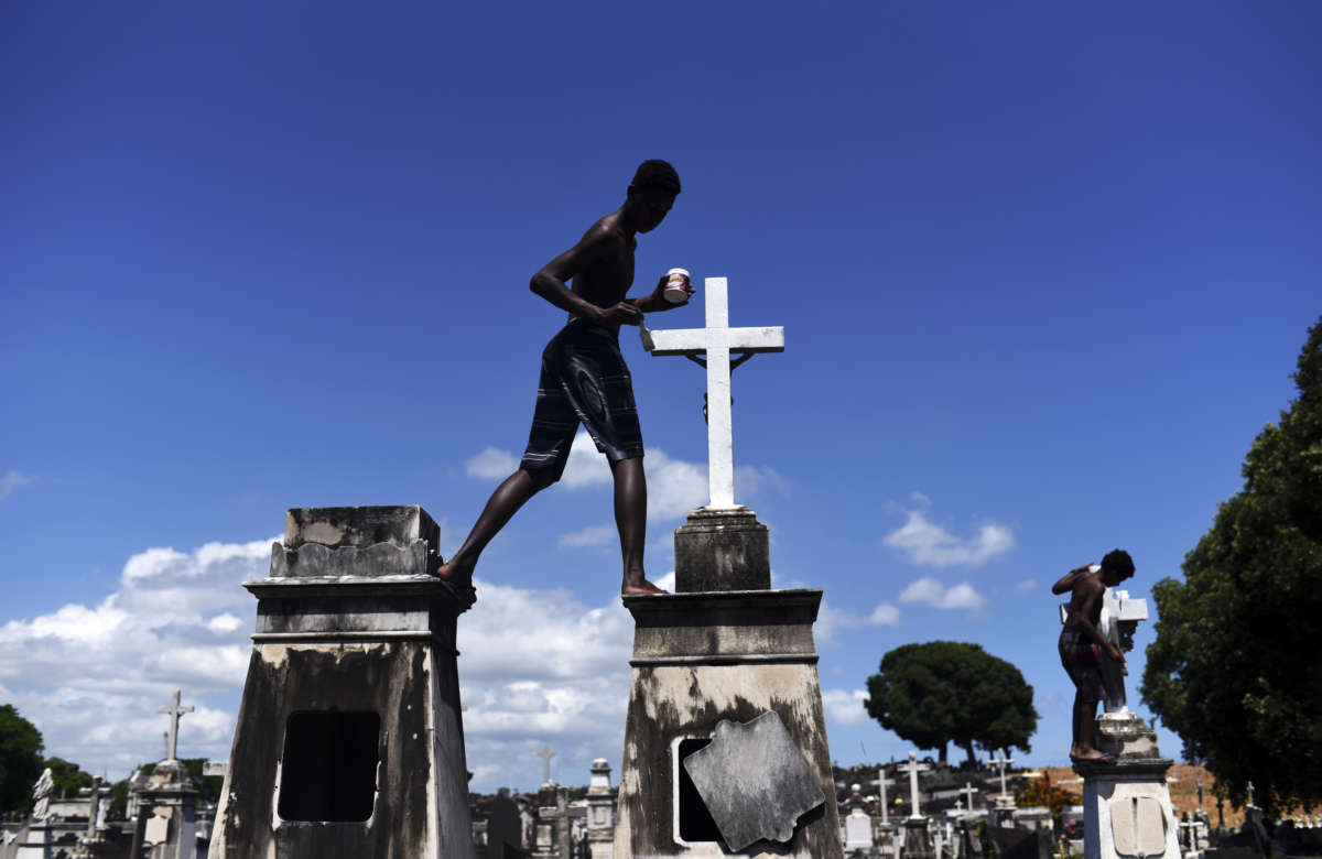 Josué Vicente Pereira and a friend painting crosses white.