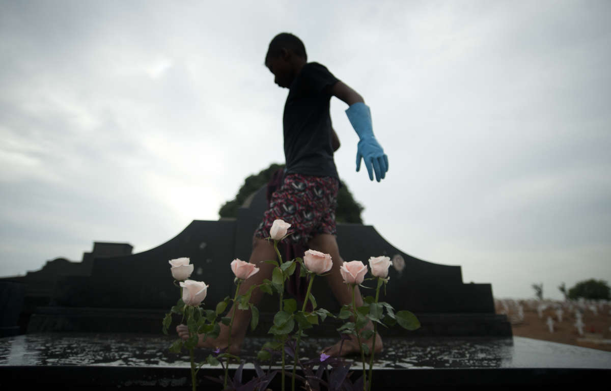 Josué Vicente Pereira cleaning a grave made of black marble in the Caju Cemetery in Rio de Janeiro, Brazil.