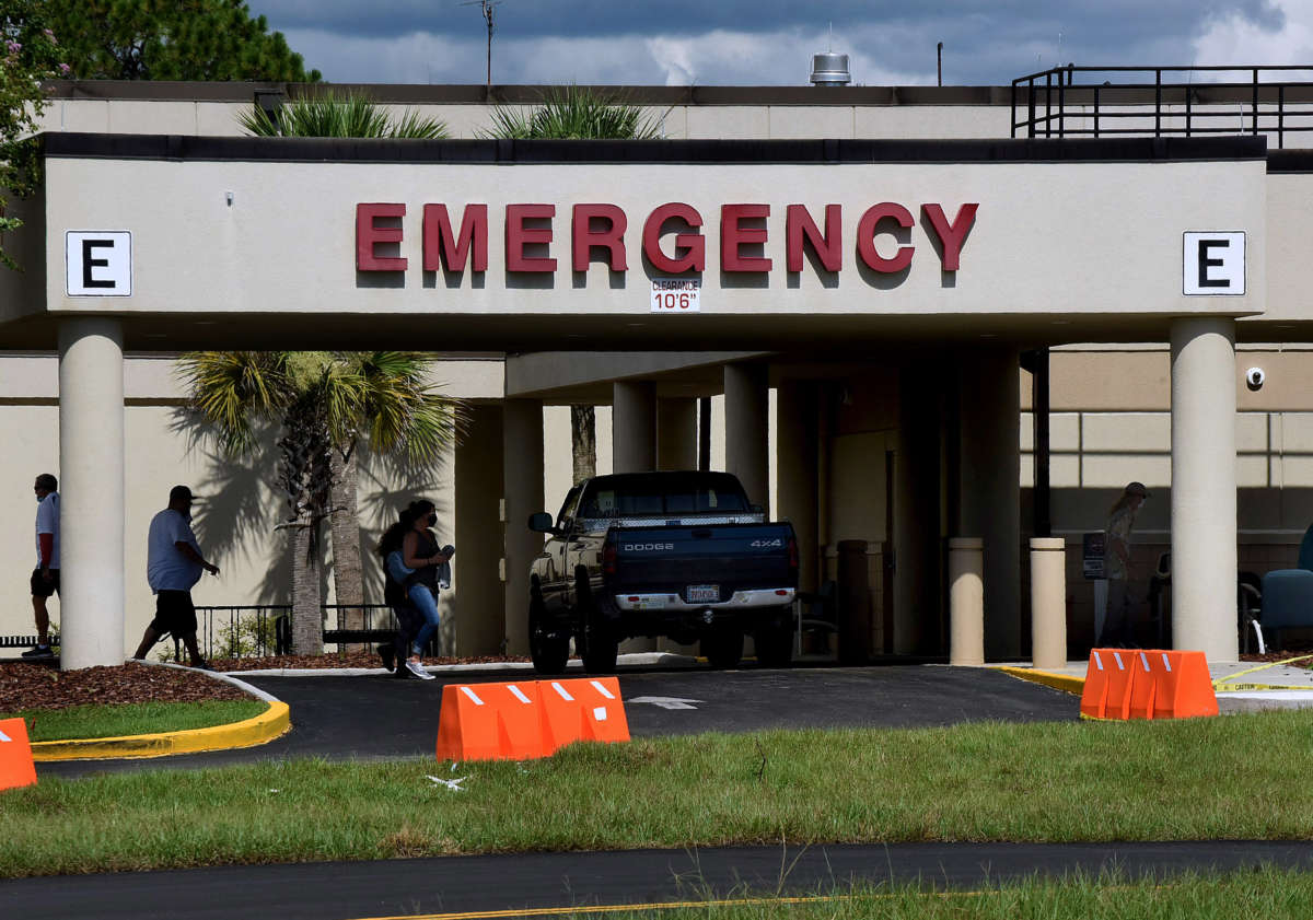 People are seen outside the entrance to the emergency room at Oak Hill Hospital in Hernando County, one of 23 counties in the state of Florida that has no available adult ICU beds.