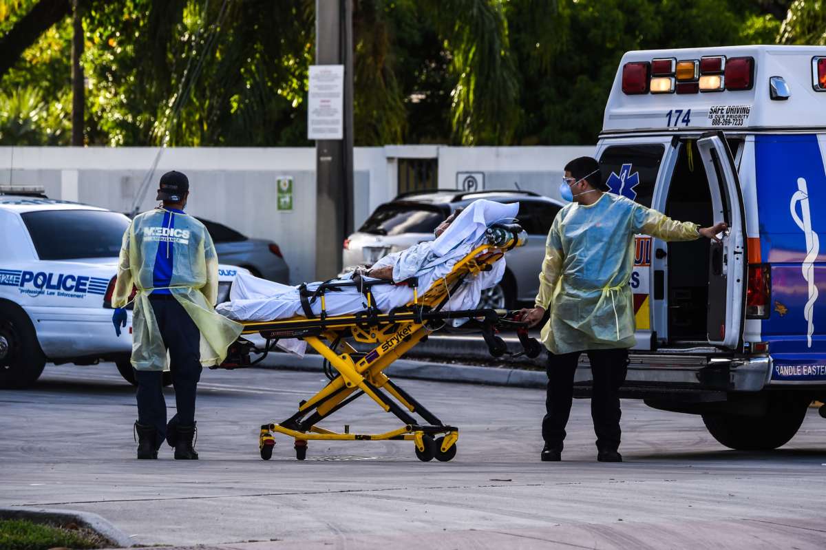Medics transfer a patient on a stretcher from an ambulance outside of the emergency room at Coral Gables Hospital where Coronavirus patients are treated in Coral Gables near Miami, on July 30, 2020.