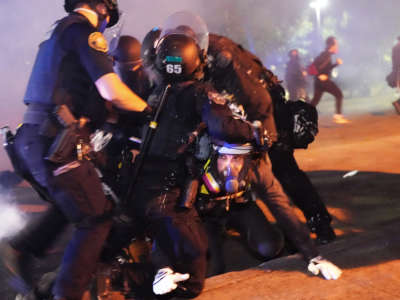 Four Portland police officers arrest a protester during a crowd dispersal near Mississippi Avenue on August 14, 2020, in Portland, Oregon.