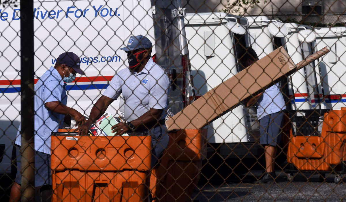 Mail carriers load their delivery trucks on August 17, 2020, in Orlando, Florida.