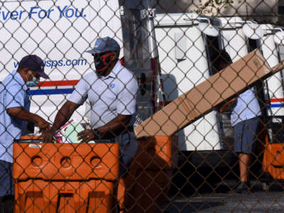 Mail carriers load their delivery trucks on August 17, 2020, in Orlando, Florida.