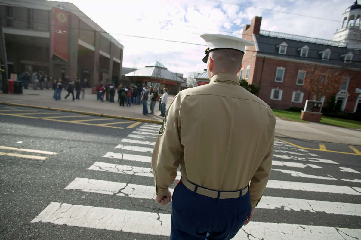 U.S. Marine recruiter Staff Sergeant Tim Norris walks across a street towards the Rutgers Student Center during a recruiting drive for officers at Rutgers University December 1, 2005, in New Brunswick, New Jersey.