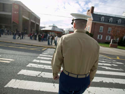 U.S. Marine recruiter Staff Sergeant Tim Norris walks across a street towards the Rutgers Student Center during a recruiting drive for officers at Rutgers University December 1, 2005, in New Brunswick, New Jersey.