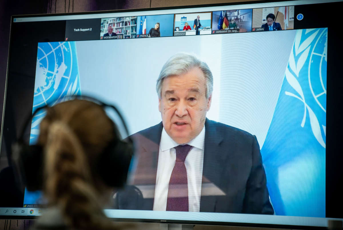 United Nations Secretary-General Antonio Guterres is seen on a screen during the video conference of the Petersberg Climate Dialogue in Berlin on April 28, 2020.