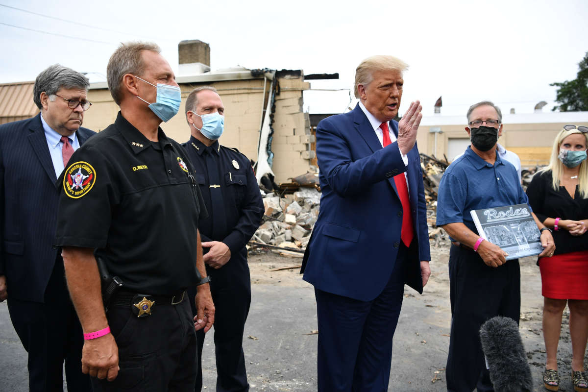 President Trump speaks alongside John Rode III, carrying a Rode's Camera Shop sign, in Kenosha, Wisconsin, on September 1, 2020.
