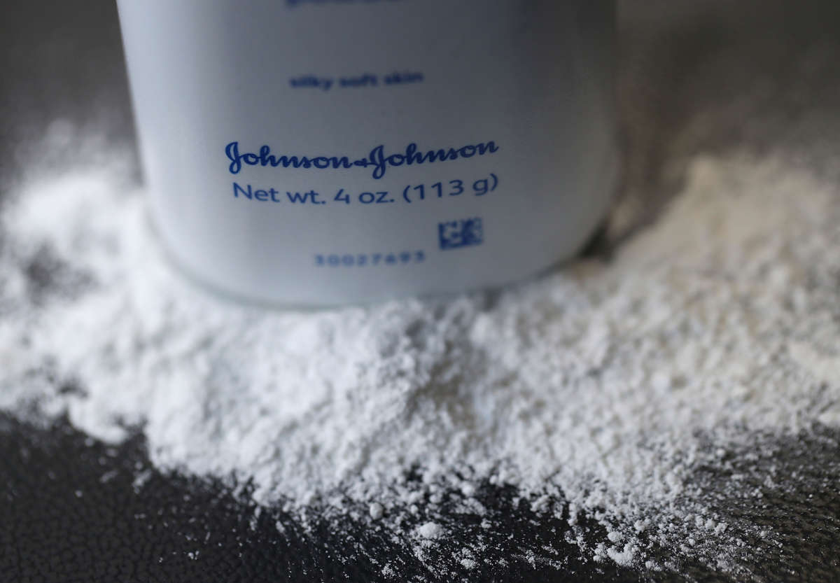 A container of Johnson's baby powder made by Johnson and Johnson sits on a table.