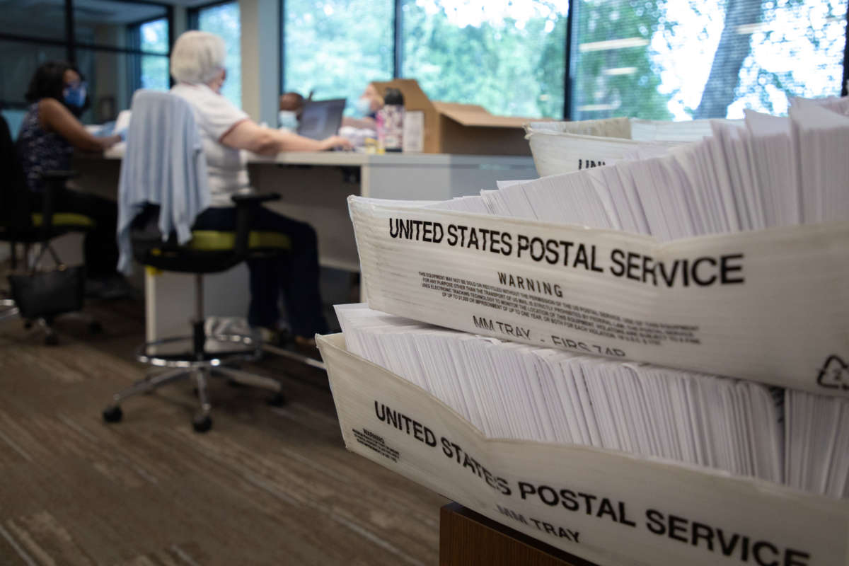 Large boxes of envelopes are seen as absentee ballot election workers stuff ballot applications at the Mecklenburg County Board of Elections office in Charlotte, North Carolina, on September 4, 2020.