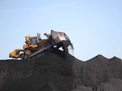 A worker moves coal around with a bulldozer