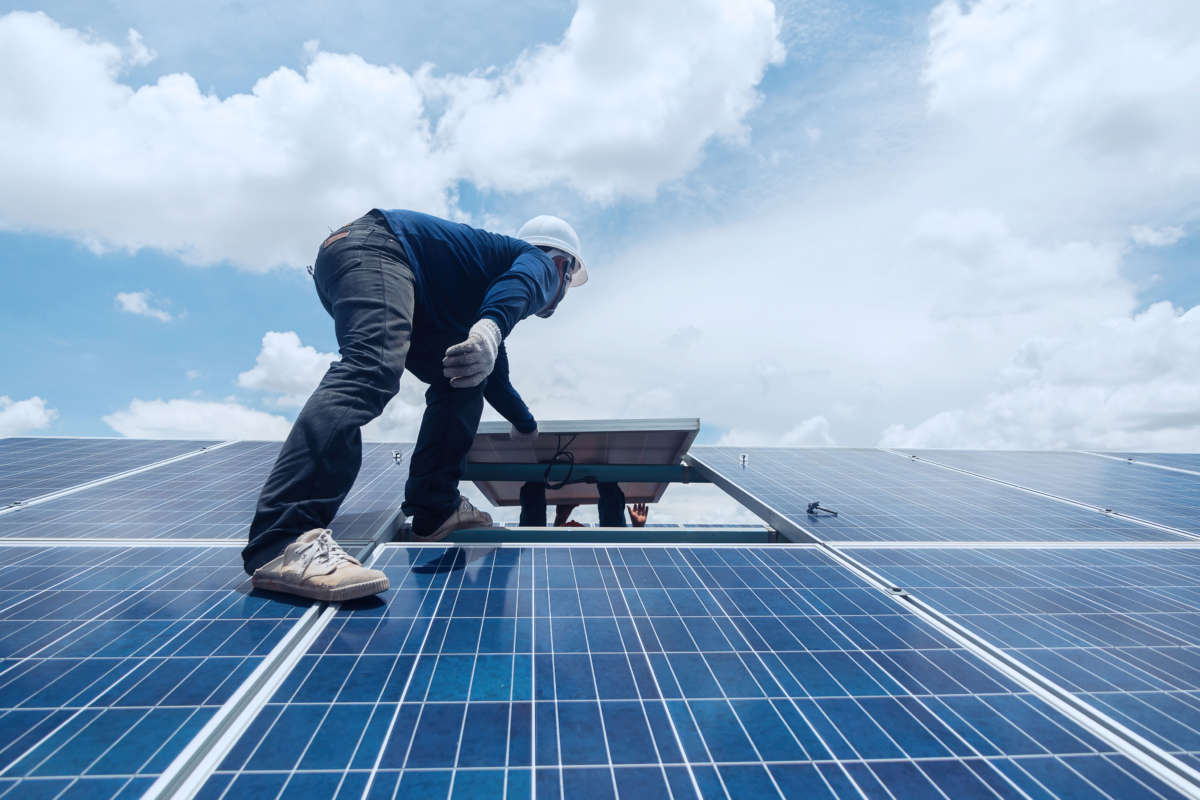 Workers replace a solar panel