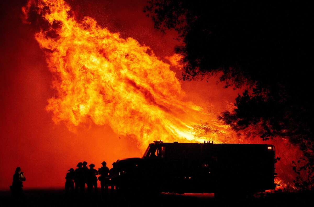 Butte County firefighters watch as flames tower over their truck during the Bear fire in Oroville, California, on September 9, 2020.