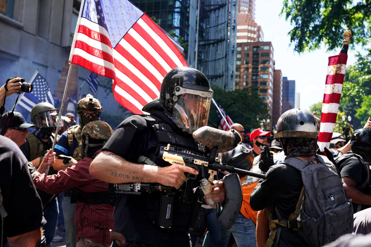 A member of the Proud Boys fires a paint ball gun into a crowd of anti-police protesters on August 22, 2020, in Portland, Oregon.